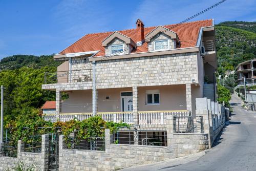 una casa con techo rojo en Guest House Ivana, en Tivat