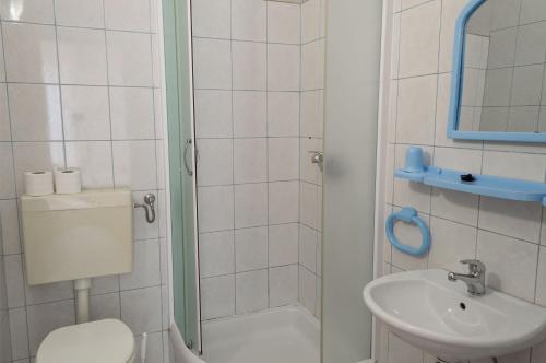 uma casa de banho com um chuveiro, um WC e um lavatório. em Apartments Ivica - Beachfront em Drvenik