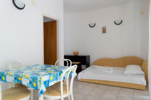 um quarto com uma cama, uma mesa e cadeiras em Apartments Ivica - Beachfront em Drvenik