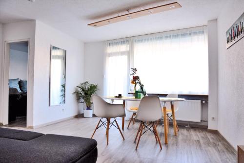 a living room with a table and chairs at Auszeit vom Alltag- schöne, moderne Wohnung am See in Immenstaad am Bodensee