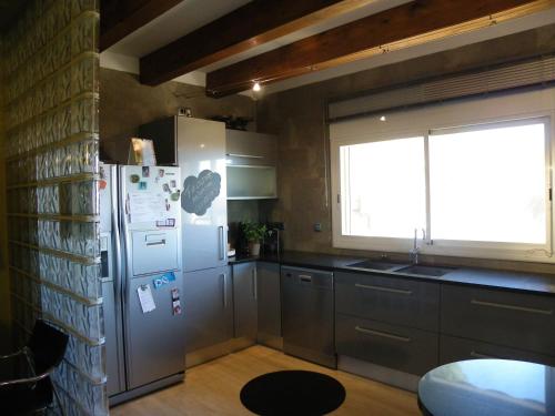 eine Küche mit einem Kühlschrank aus Edelstahl und einem Fenster in der Unterkunft Apartamento Caballito de Mar in L'Estartit