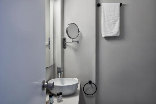 a bathroom with a sink and a mirror at High Mill Paros Hotel in Parikia