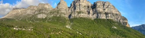 a large rocky mountain with trees on it at Chariklia Traditional House in Papigko