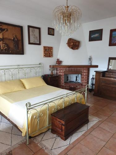 a bedroom with a bed and a fireplace and a chandelier at Ca' Olivella in Casarza Ligure