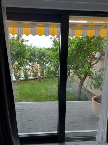 a window with a view of a yard at MORE Podgora Luxury Design Apartment in Podgora