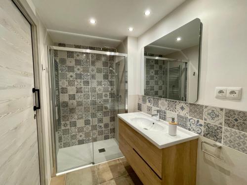 a bathroom with a sink and a shower with a mirror at Casa Dunia in Valderrobres