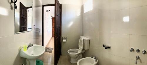 a bathroom with a sink and a toilet and a sink at Hostal Los Faroles Chicoana in Chicoana
