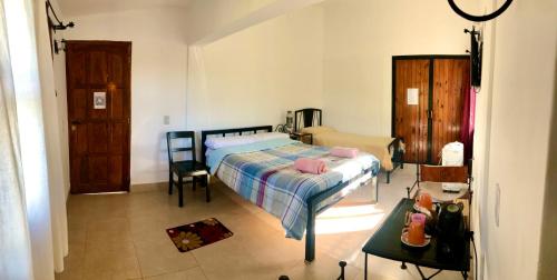 Un dormitorio con una cama y una mesa. en Hostal Los Faroles Chicoana en Chicoana