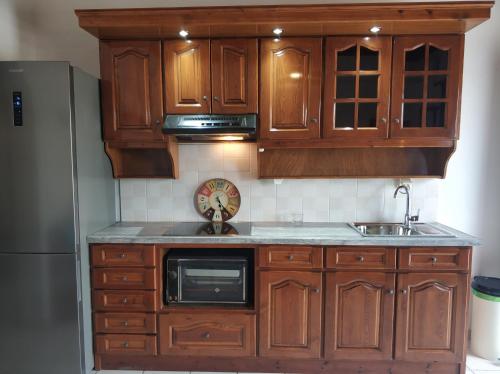 a kitchen with wooden cabinets and a refrigerator at Litus Amoris in Sidari