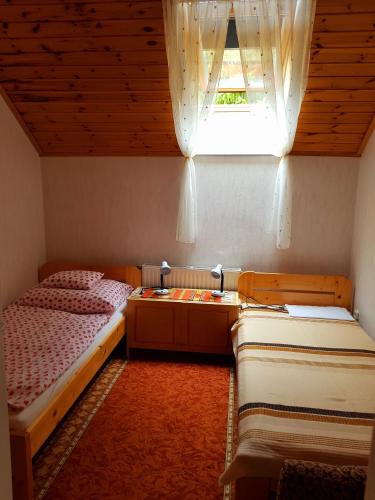 a bedroom with two twin beds and a window at Borostyán Apartmann in Balatonföldvár