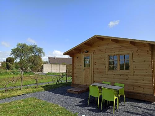a cabin with a table and chairs in front of it at Verton, Gîte Les chalets du Fliers Meublés de tourisme classés 2 étoiles plage de BERCK SUR MER in Verton