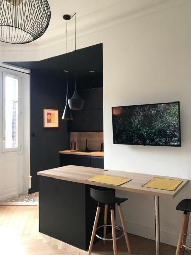 a kitchen with a counter and a table with stools at Studio 329 in Aix-les-Bains