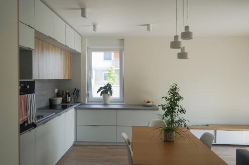 a kitchen with white cabinets and a wooden table at Czartoryskiego 32 in Wrocław