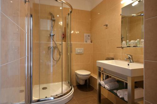 a bathroom with a shower and a sink and a toilet at Hotel U Ricordu & Spa in Macinaggio
