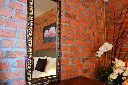 a mirror on a brick wall with a bed in it at The Ocean Residence Langkawi in Kuah