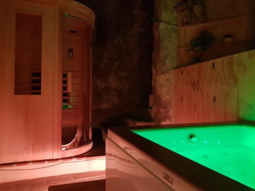 een badkamer met een bad met een groen aanrecht bij La grotta nel borgo in Roccastrada