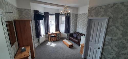 een woonkamer met een bank en een tafel bij Brooke House in Shanklin