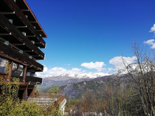 uma vista para as montanhas cobertas de neve a partir de uma casa em Pra-Loup 1600, Front de Neige em Pra-Loup