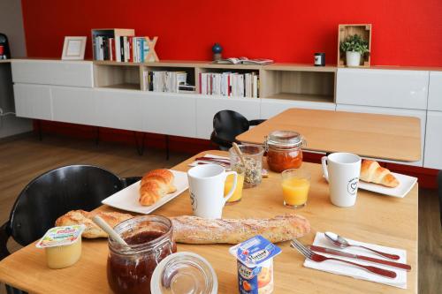 a table with food and drinks and bread on it at Hôtel et Apparts Marin in Laval