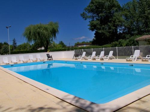 a large swimming pool with lounge chairs and a volley ball court at Camping les Peupliers in Vendays-Montalivet