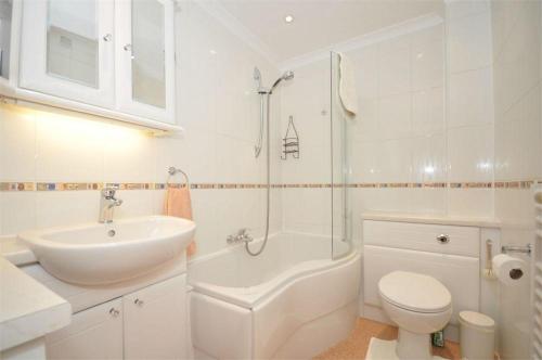 ステーンズにあるThames View Apartmentsの白いバスルーム(洗面台、トイレ、シャワー付)