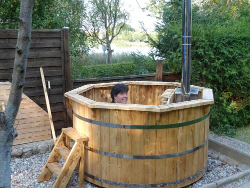 a woman sitting in a wooden hot tub at Ferienwohnung Last in Kyritz