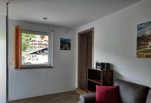 - un salon avec une fenêtre et un canapé dans l'établissement G & H Ferienwohnungen Appartement Almrausch, à Berchtesgaden