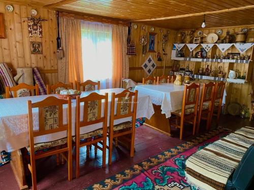 comedor con mesa y algunas sillas en Casa Agroturistica Tarancuta din Vatra Moldovitei, en Vatra Moldoviţei