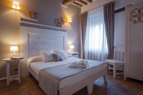 a bedroom with a large white bed and a window at Borgo San Faustino Country Relais and Spa Orvieto in Orvieto