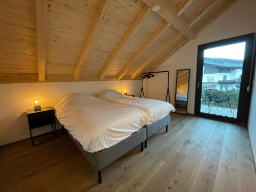 a bedroom with a bed and a large window at Luxury Chalet Mauthner Alm in Kötschach