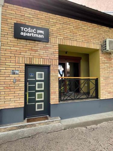 a building with a door and a sign on it at Tošić apartman in Sombor