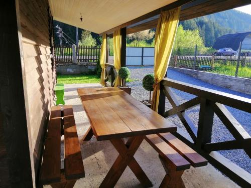 a wooden table and bench on a porch at Гостинний двір" Живиця" ЧАН in Mizhhirʼʼya