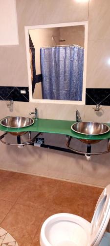 a bathroom with two sinks and a toilet at El Castillo Monte Campana in Puntarenas