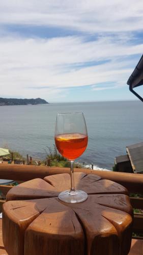 a glass of wine sitting on top of a wooden table at Cabańas de La Ochi in Niebla