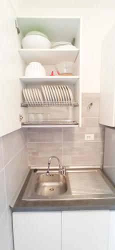 a kitchen with a sink and white cabinets at Casa Garbein in Rimini