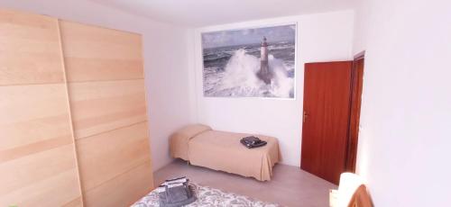 una camera con un letto e una foto appesa al muro di Casa Garbein a Rimini