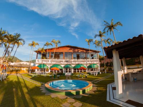 ein Resort mit einem Pool und Palmen im Hintergrund in der Unterkunft Hotel Recanto dos Pássaros in São Sebastião