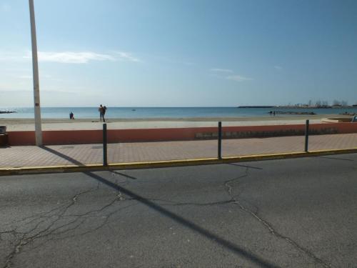 een hek aan de kant van een strand met de oceaan bij Studio Sirène à 20 m de la plage in Palavas-les-Flots