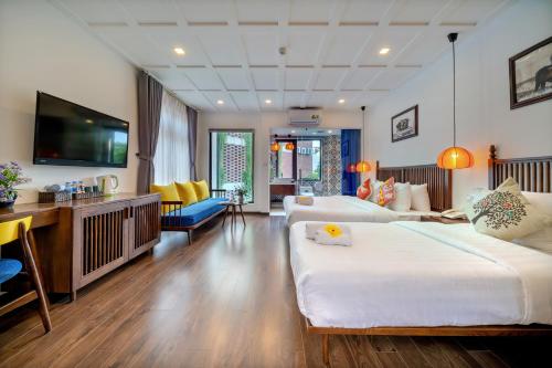 Habitación de hotel con 2 camas y TV de pantalla plana. en Son Trang Hotel Hoi An, en Hoi An
