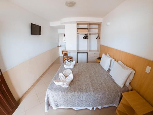 ein Schlafzimmer mit einem Bett mit zwei Handtüchern darauf in der Unterkunft Hotel Recanto dos Pássaros in São Sebastião