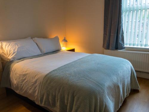 Schlafzimmer mit einem großen Bett und einem Fenster in der Unterkunft Home Away From Home in Sheffield