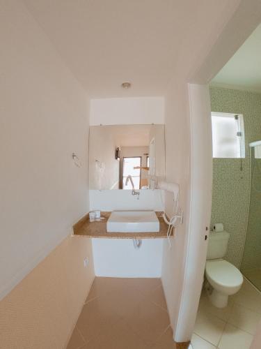 a white bathroom with a sink and a toilet at Hotel Recanto dos Pássaros in São Sebastião