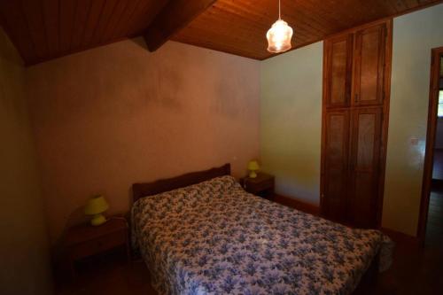 - une chambre avec un lit et un plafond en bois dans l'établissement gite 6 personne, à La Bécade