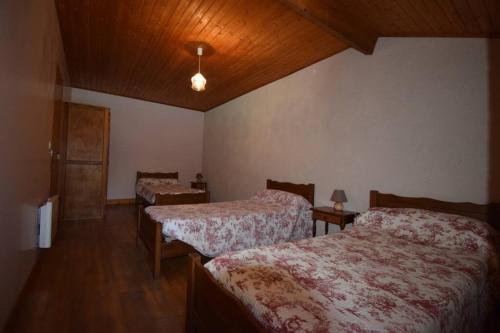 een slaapkamer met 2 bedden en een houten plafond bij gite 6 personne in La Bécade