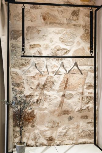 a wall with hangers hanging on a wall at Amoretta rooms in Šibenik