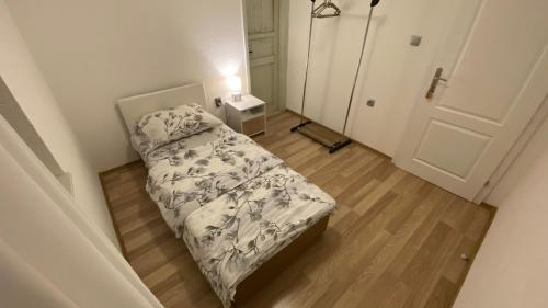 a small bedroom with a bed and a door at Stone House in Posušje