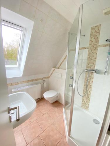 uma casa de banho com um chuveiro, um lavatório e um WC. em Strandliebe Markgrafenheide em Rostock