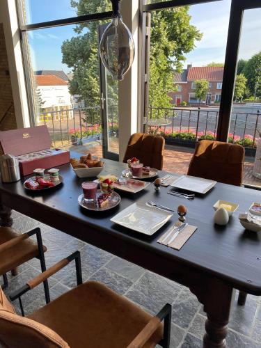 een tafel met eten in een kamer met ramen bij Atalanta-Wellness Roermond 'de Wethouder' in Herten