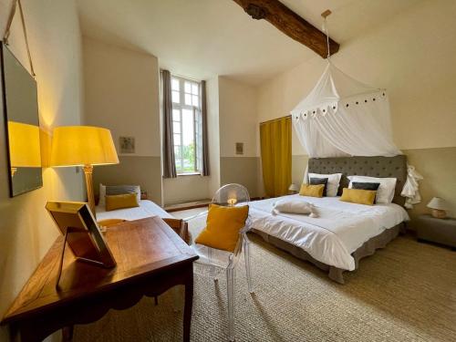 a bedroom with a large white bed and a desk at Manoir de la Bégaudière in Mont-Dol