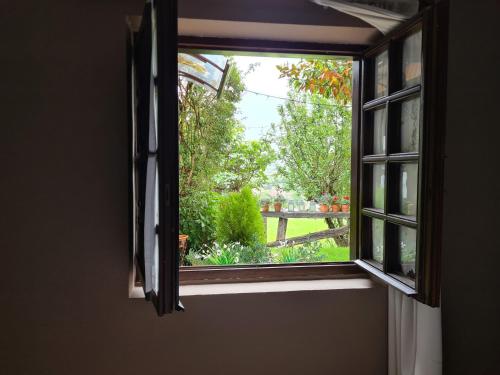 an open window with a view of a garden at Hotel Colegiata in Santillana del Mar
